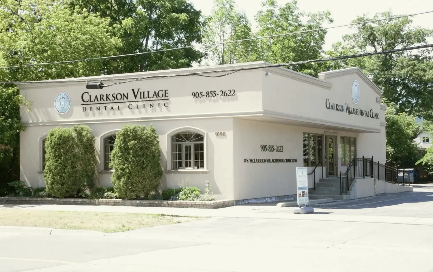 The Clarkson Village Dental Clinic building at 1098 Clarkson Road North, Mississauga, with its signage and tree-lined entrance on a summer day